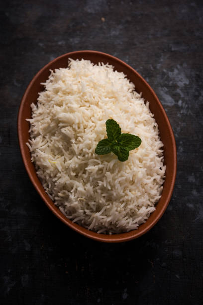 istock Cooked plain white basmati rice in terracotta bowl over plain or wooden background 925593544