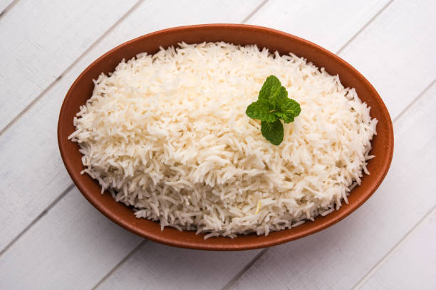 istock Cooked plain white basmati rice in terracotta bowl over plain or wooden background 925593720