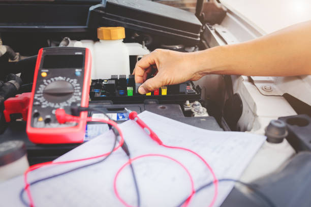Auto mechanic using digital multimeter to check the fuse in a car,check voltage level car battery.