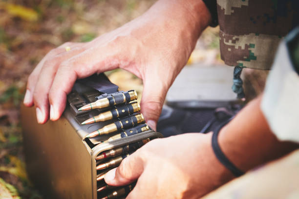 istock Hands of soldier holding ammunition. 925600452