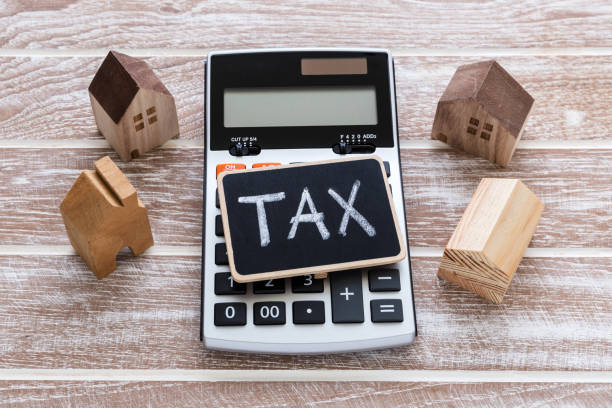istock Tax sign on calculator with house model 925604468