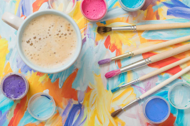 istock paints, brushes and cup of coffee on paper 925605582