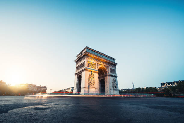Morning Traffic At Arc De Triomphe Traffic around the Arc de Triomphe at sunrise (Paris, France). triumphal arch photos stock pictures, royalty-free photos & images