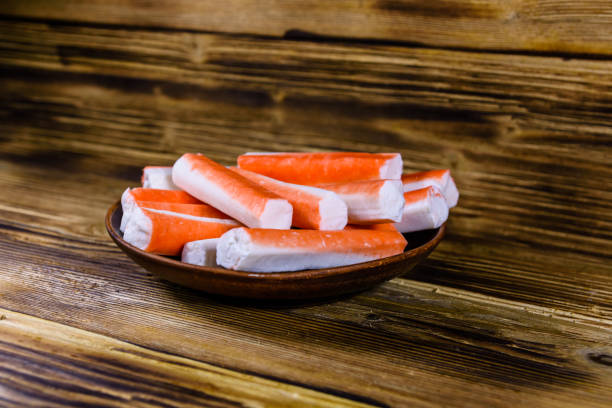 istock Ceramic plate with crab sticks on wooden table 925608610