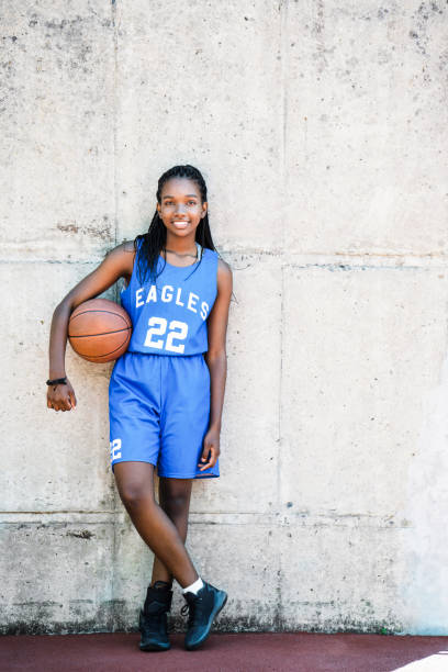 istock Confident female player holding ball at court 925612146