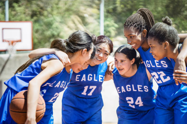 joueurs de basket féminin se blottir sur cour - child basketball uniform sports uniform photos et images de collection