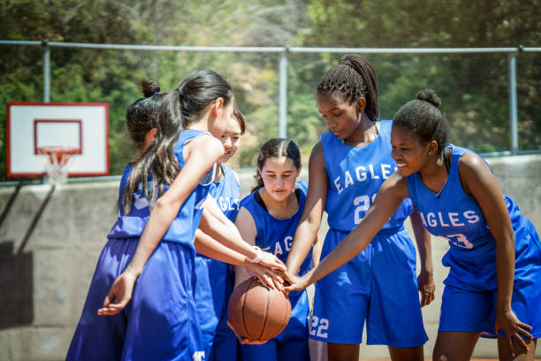istock Female basketball players stacking hands on ball 925612320