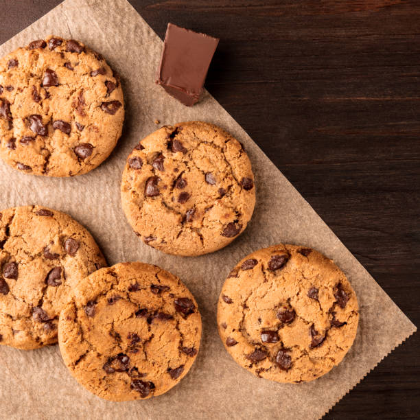 istock Chocolate chips cookies on baking paper with copyspace, square photo 925614976