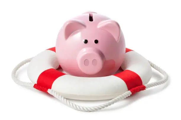 Photo of Financial rescue. Piggy bank with lifebouy on white background.