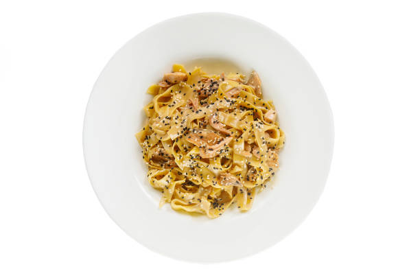 Pasta, noodles with fish and sesame, decorated with cheese. Isolated white view from above Serving a meal in a cafe, restaurant.