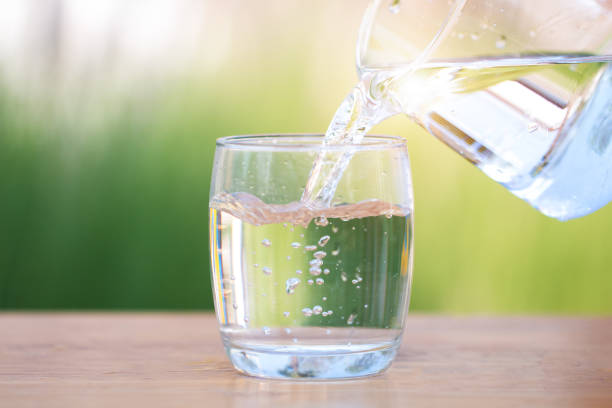 istock Glass of water on nature background. 925628134