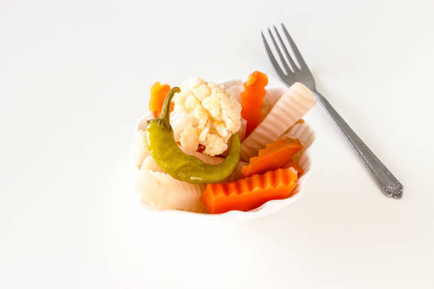 istock Assorted pickles vegetables in white bowl and fork. Top view. Isolated. 925631984