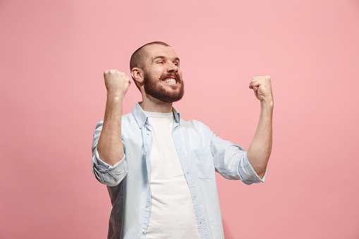 I won. Winning success happy man celebrating being a winner. Dynamic image of caucasian male model on pink studio background. Victory, delight concept. Human facial emotions concept. Trendy colors