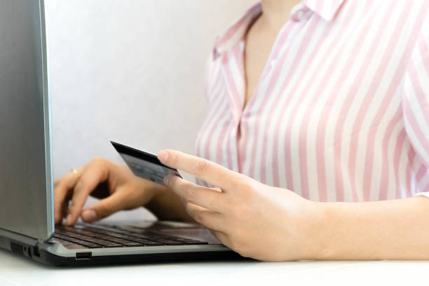 istock Hands holding a credit card and using laptop computer for online shopping. Credit Card Online Technology Shopping. Close up of female hands making online payment 925636302
