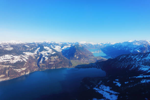 Bernese Apline city of Interlaken at winter Swiss Alpine mounts The center of Bernese Apline city of Interlaken at winter Swiss Alps, helicopter view. Thun Lake and Brienz Lake on background thun interlaken winter switzerland stock pictures, royalty-free photos & images