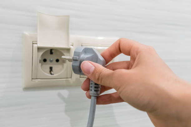 istock woman hand puts plug in the socket, closeup shot. Hand Putting Plug Into Electricity Socket. Female hand unplugging a plug from a socket 925638706