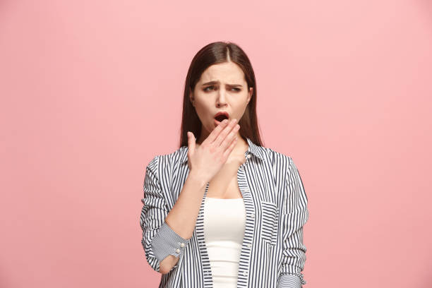 beautiful bored woman bored isolated on pink background - one person people boredom isolated imagens e fotografias de stock