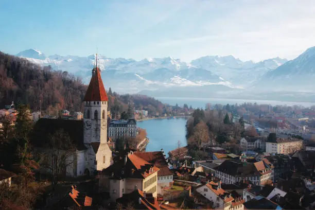 Panorama of City Church and Town of Thun with Alps and Thunersee. Thun is a city in the canton of Bern,  Switzerland, where the Aare river flows out of Lake Thun. There is a view of Bernese Alps.