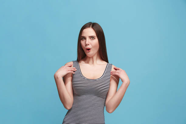istock Beautiful woman looking suprised isolated on blue 925640106