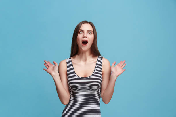 istock Beautiful woman looking suprised isolated on blue 925640120