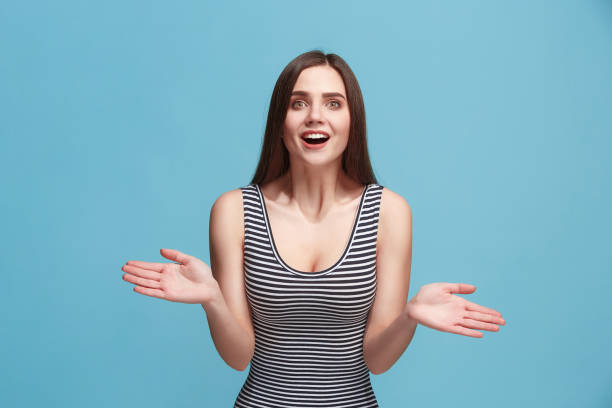 istock Beautiful woman looking suprised isolated on blue 925640236