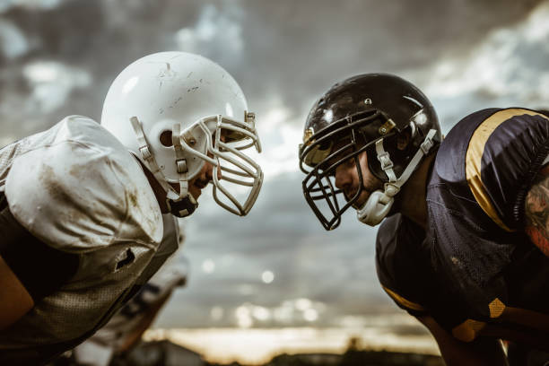 jogadores de futebol americano, confrontando-se antes do início de uma partida. - offensive line - fotografias e filmes do acervo