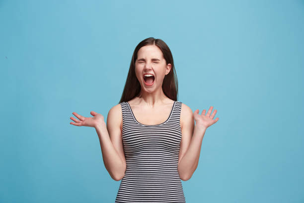 istock The young emotional angry woman screaming on blue studio background 925640888
