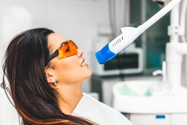 Teeth whitening in dental clinic for female patient stock photo
