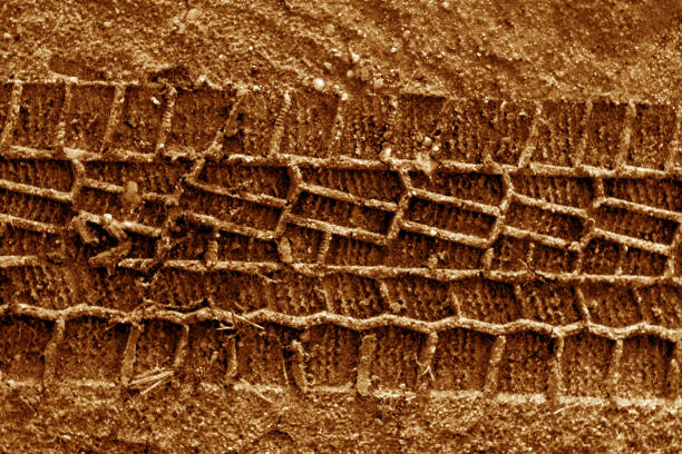 istock Tyre tracks on sand in orange tone 925644398
