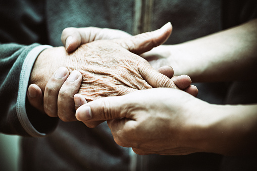 Elderly hand and caregiver