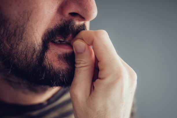 nervous male biting fingernails - nail biting imagens e fotografias de stock