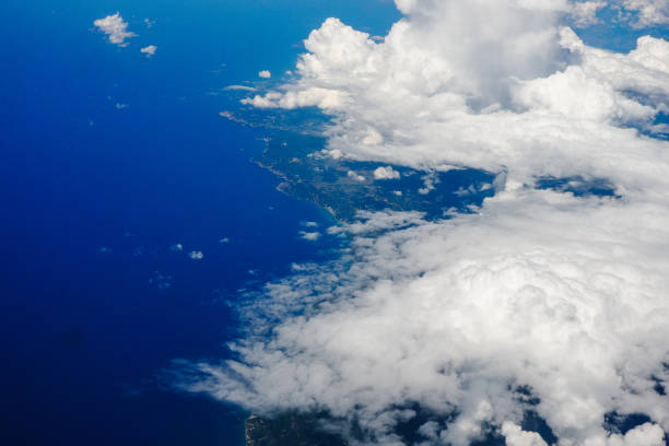 Blue sky and clouds below from airplane window