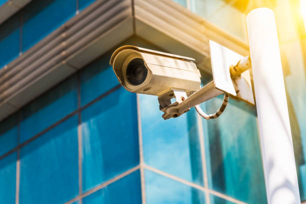 istock surveillance camera with modern buildings on background 925654188
