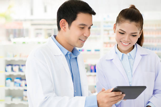 化学者の店や薬局で働くアジア薬剤師チーム - pharmacy pharmacist smiling pill ストックフォトと画像