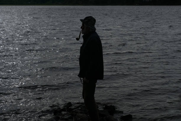 istock Silhouette of an old fisherman smoking a pipe 925660830