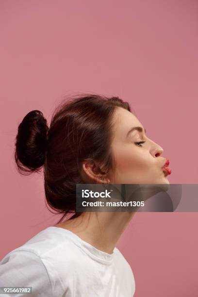 Portrait Of Attractive Cute Girl With Bright Makeup With Kiss Isolated Over Pink Background Stock Photo - Download Image Now