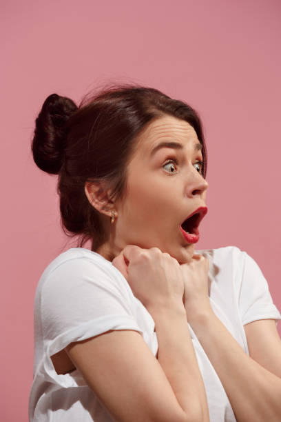 istock Beautiful woman looking suprised isolated on pink 925664182