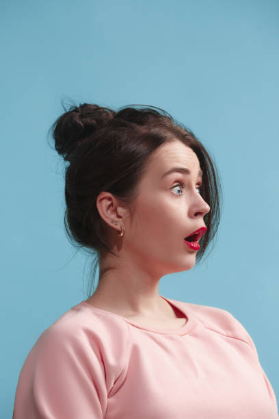 istock Beautiful woman looking suprised isolated on blue 925664504