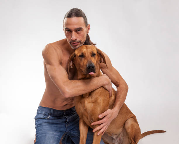 istock Shirtless muscular man embracing with his dog 925665572