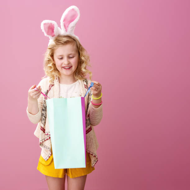 istock happy modern child on pink background looking at shopping bag 925671784
