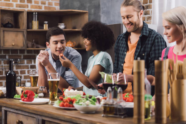istock multiethnic friends tasting some food while cooking in kitchen 925674104