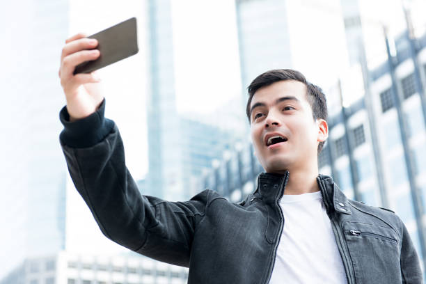 istock Male tourist using camera on smartphone taking selfie outdoors in the city 925677264