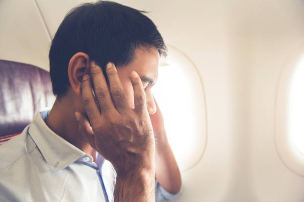 istock Male passenger having ear pop on the airplane 925678370