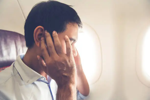 Photo of Male passenger having ear pop on the airplane