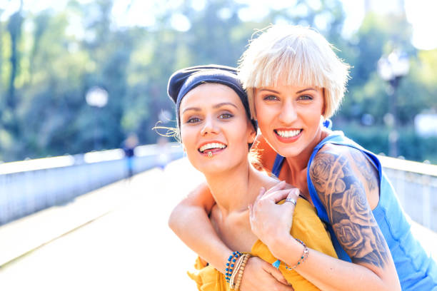 istock Two women embracing on bridge and looking at camera 925681056