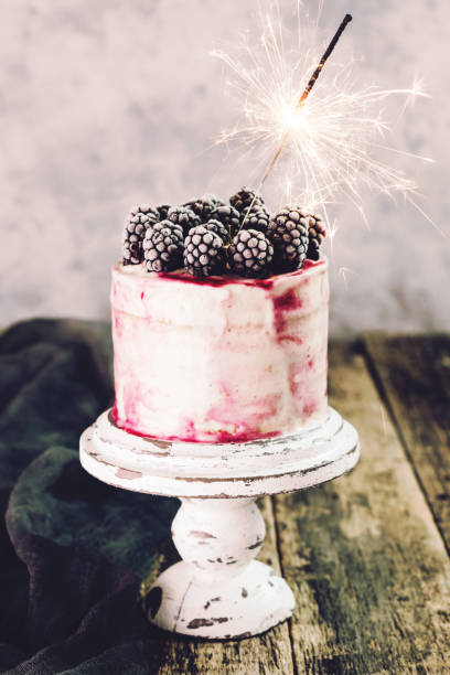 istock Birthday cake with sparkler on wooden vintage table 925681164