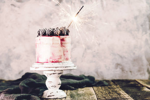 istock Birthday cake with sparkler on wooden vintage table 925682020