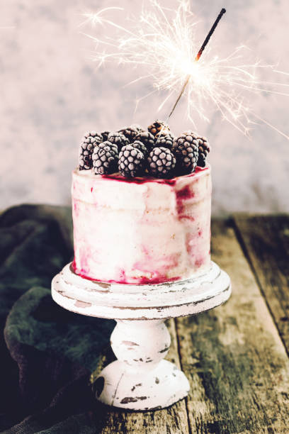 istock Birthday cake with sparkler on wooden vintage table 925682376