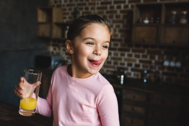 child drinking orange juice adorable happy child drinking orange juice and licking lips juice drink stock pictures, royalty-free photos & images
