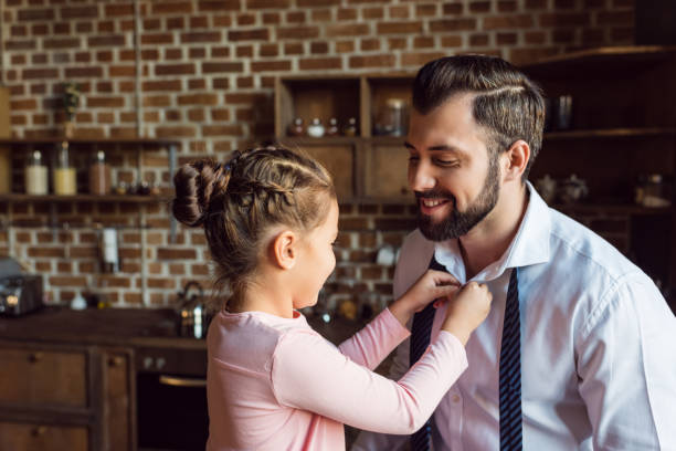 istock daughter buttoning shirt for father 925684814